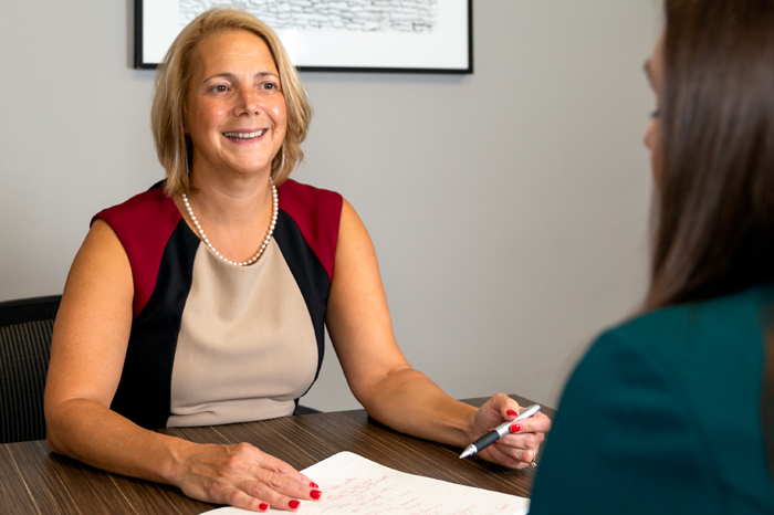 Woman sitting at desk with client