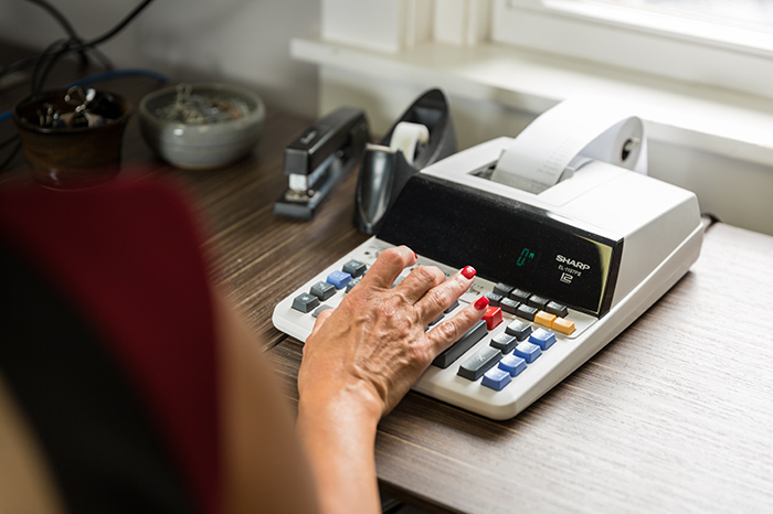 Hand typing on printing calculator