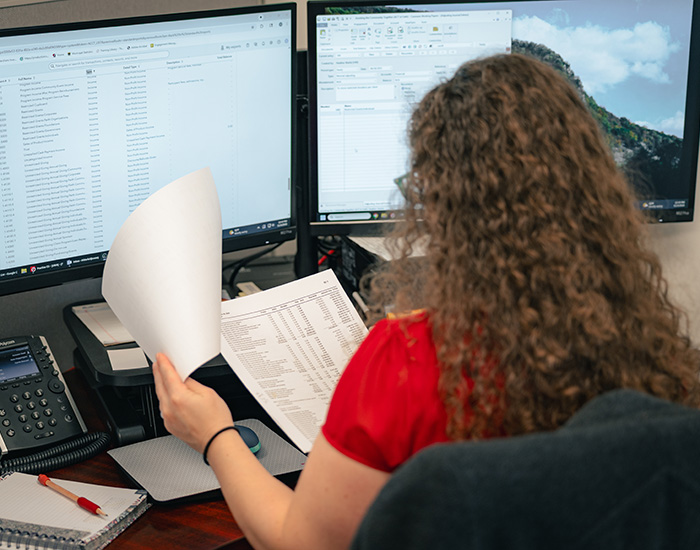 Umbreit, Wileczek & Associates accountant reviewing financial files in front of computer